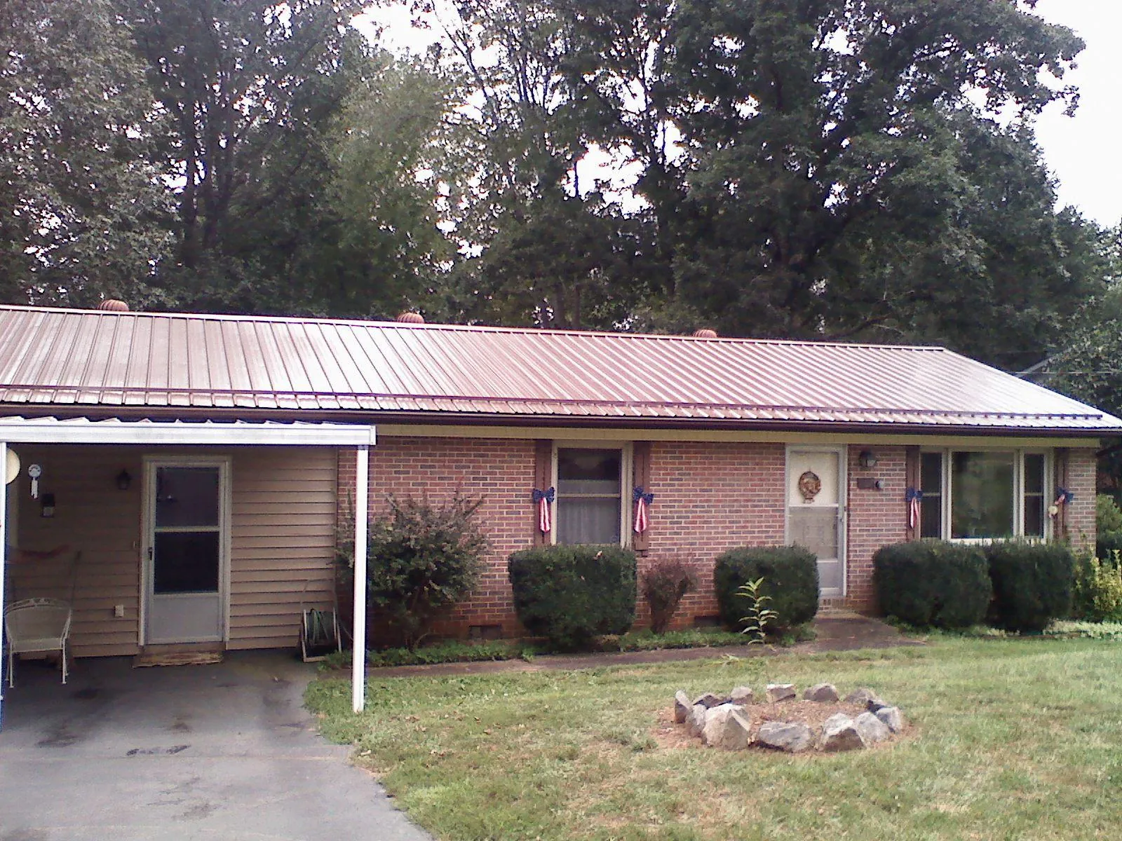 Bronze metal roof and carport on a brick ranch home — Roof Repair work by our crew in Somerville